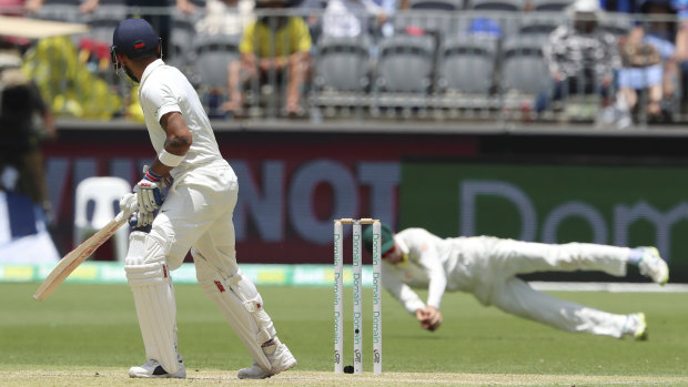 Pivotal moment: Virat Kohli looks behind to watch Peter Handscomb take a catch ruled to be legitimate.