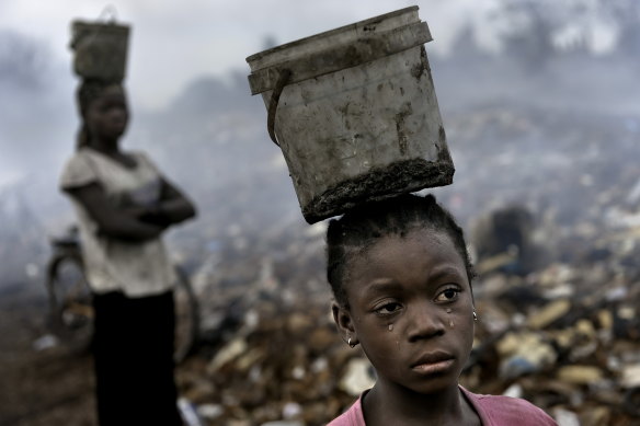 In Ghana, West Africa, Fati, 8, works with other children searching through hazardous waste. 