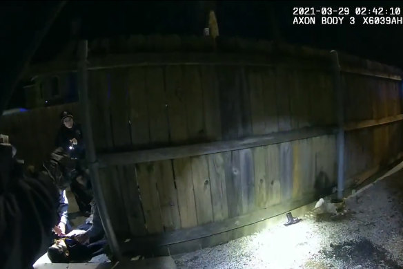 Chicago Police Department body-cam video shows officers doing CPR on Adam Toledo (lower left) after he was shot by an officer. A gun is seen on the ground by the fence, (lower centre).