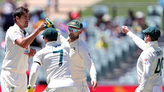 Australia’s Mitchell Starc, center, is congratulated by teammates after taking the wicket of India’s Wriddhiman Saha on the second day of their cricket test match at the Adelaide Oval in Adelaide, Australia, Friday, Dec. 18, 2020. (AP Photo/James Elsby)