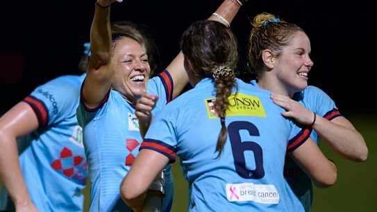 Iliseva Batibasaga embraces teammates after the Waratahs progressed to the Super W final.