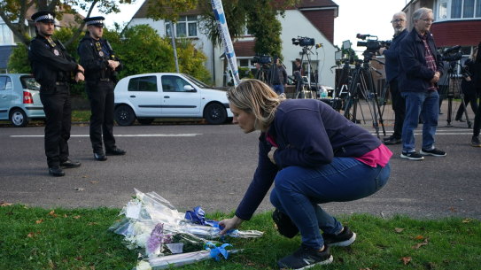 A woman lays flowers in Leigh-on-Sea, Essex, near where British MP Sir David Amess was murdered. 