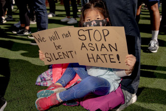 A child holds signs during an AAPI Rally Against Hate in New York on Sunday.