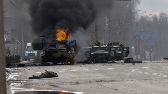A Russian armoured personnel carrier burns in Kharkiv.