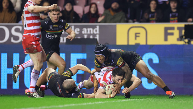 Jake Wardle dives for the tryline as Brian To’o tries to hold the Wigan player up.