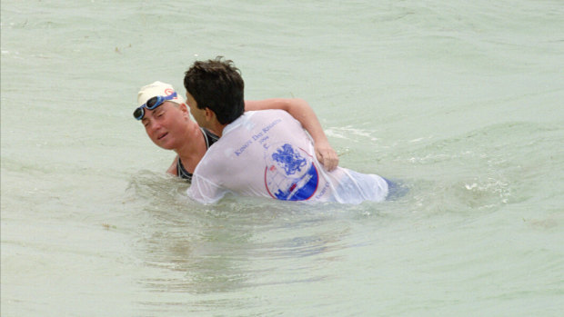 Australian swimmer Susie Maroney reaches the shore after completing the crossing between Cuba and the Florida Keys. Maroney’s doctor, Dr. Stein, who has coached her for the record breaking swim, helps her to shore.
