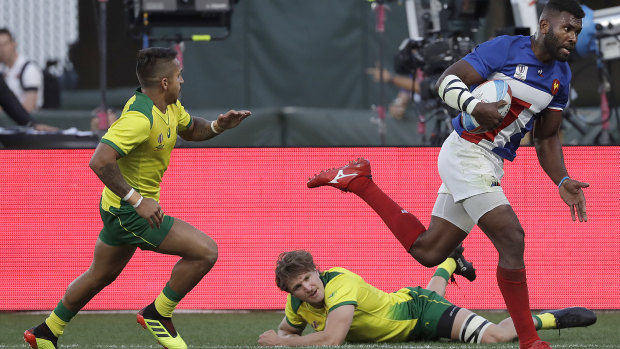 Tavite Veredamu, right, scores France's winning try to knock Australia out of the main competition of the Rugby Sevens World Cup in San Francisco on Friday (US time).