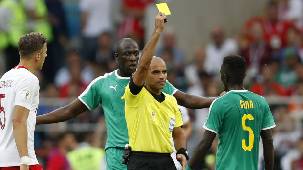Senegal's Idrissa Gana Gueye is shown a yellow card during the match against Poland.