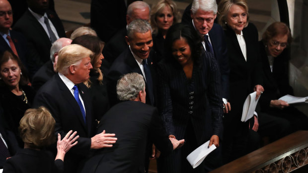 Former president George W. Bush shares a joke with Michelle Obama.