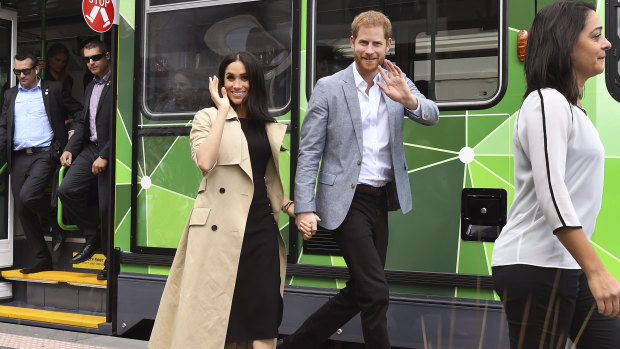 Prince Harry and his wife, Meghan, Duchess of Sussex, wave to the well-wishers after taking a ride on a Melbourne tram.
