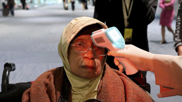 A health official scans the body temperature of a passenger at Jakarta's Soekarno-Hatta International Airport.