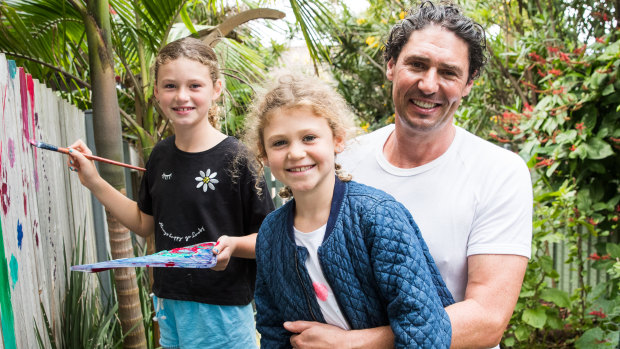 Chef Colin Fassnidge with his daughters, Lily, 10, and Maeve, 9, who are spending Easter weekend cooking and painting flowers on the vegetable garden fence. 