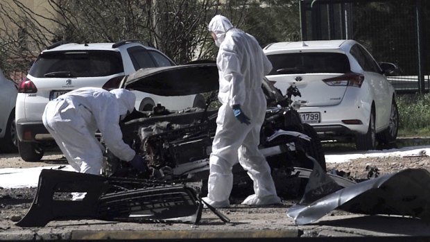 Forensic experts examine the scene of the blast in the upscale Glyfada area .
