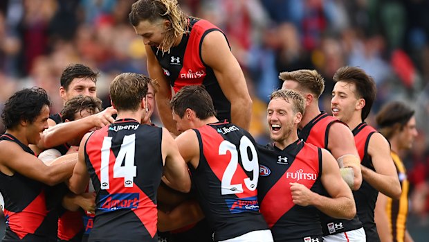 Anthony McDonald-Tipungwuti is under there somewhere. The Bombers mob the small forward after kicking a goal in his return match.