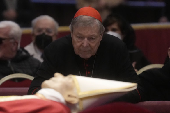 Australian Cardinal George Pell stands next to the body of late Pope Emeritus Benedict XVI.