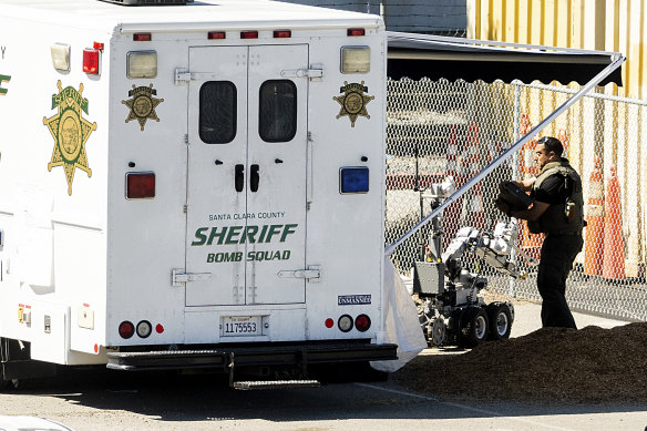 An emergency responder stows a bomb squad robot following the shooting in San Jose.