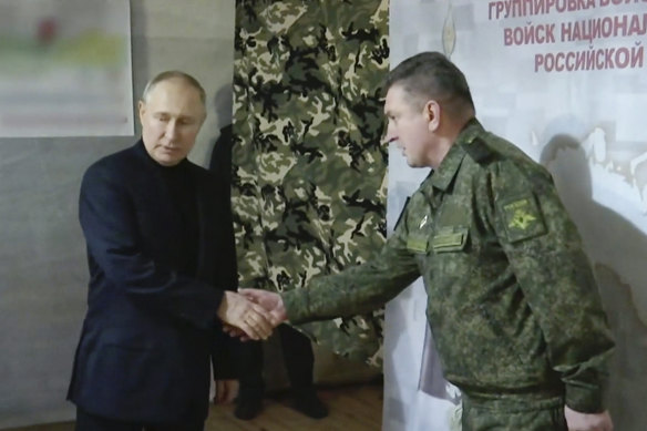 Russian President Vladimir Putin meets Colonel General Alexander Lapin during a visit to the headquarters of the Vostok National Guard in the Russian-controlled Luhansk region, in eastern Ukraine. The photo was released by Russian TV Pool last week.