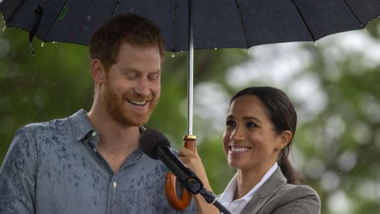 Tim impian: Meghan memayungi Pangeran Harry dari hujan saat dia berbicara di piknik komunitas.
