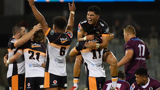 Brumbies players celebrate after their opening-round victory over the Reds in blistering heat in Canberra on Friday.