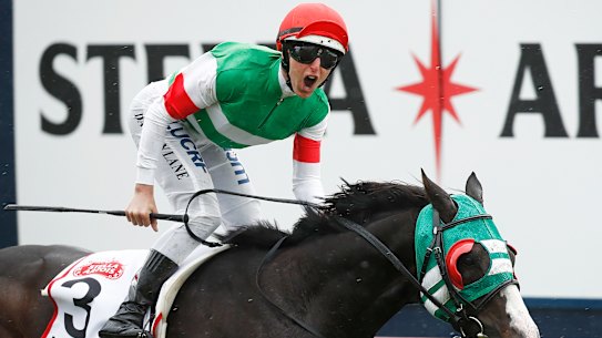 Damian Lane gives a yell as he takes the Caulfield Cup on Mer De Glace.