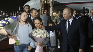 Russian President Vladimir Putin, foreground right, walks with released Russian prisoners and relatives upon their arrival at the Vnukovo government airport outside Moscow, Russia.