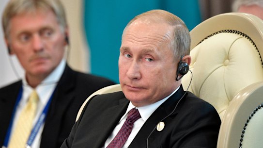 Russian President Vladimir Putin, front, and his spokesman Dmitry Peskov.