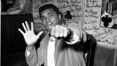 Cassius Clay holds up five fingers to predict how many rounds it will take him to knock out Henry Cooper in London in May 1963.