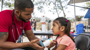 Dr Dairon Elisondo Rojas, a doctor from Cuba, treats Estephanie, 4, for asthma.