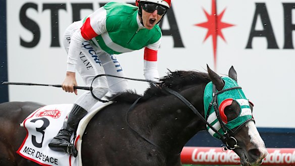 Damian Lane gives a yell as he takes the Caulfield Cup on Mer De Glace.
