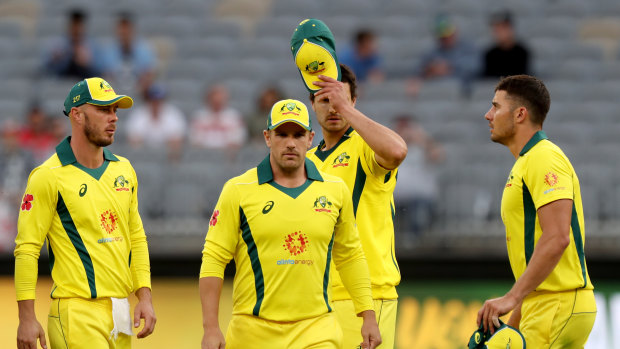 Long walk: The Australians leave the field after the heavy defeat in Perth.