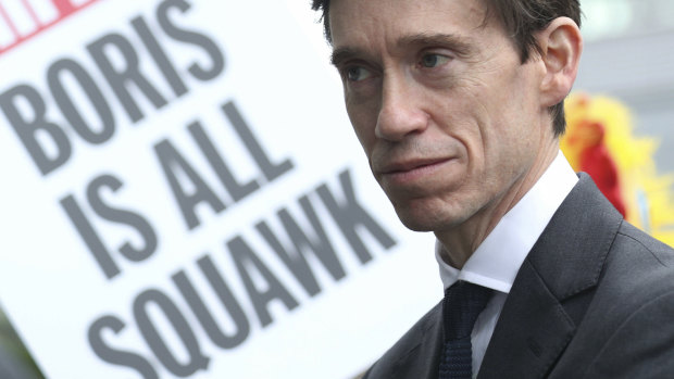 A poster is brandished behind Conservative party leadership contender Rory Stewart as he arrives at the studios for a live television debate for the Conservative Party leadership in London. 