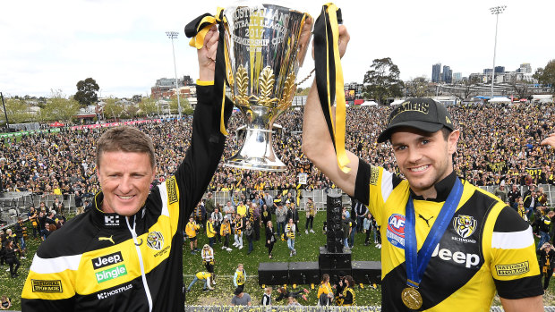 Richmond coach Damien Hardwick and captain Trent Cotchin flaunt the 2017 premiership cup at the club's Punt Road headquarters.