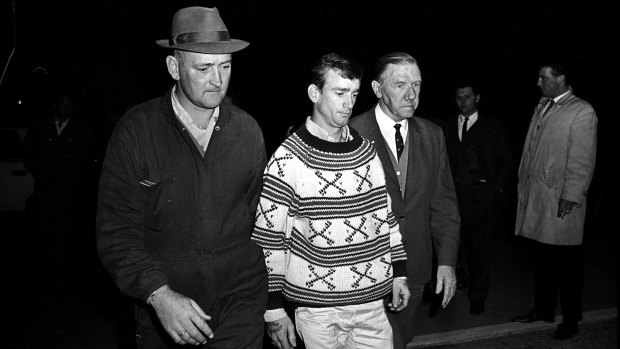 The Police Commissioner, Mr. Norman Allan (right), walks beside Wally Mellish at the Ingleburn Army Camp after his surrender