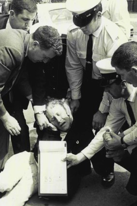 "Demonstrator winces in pain after being judo chopped in the face by security guard." January 15, 1970.