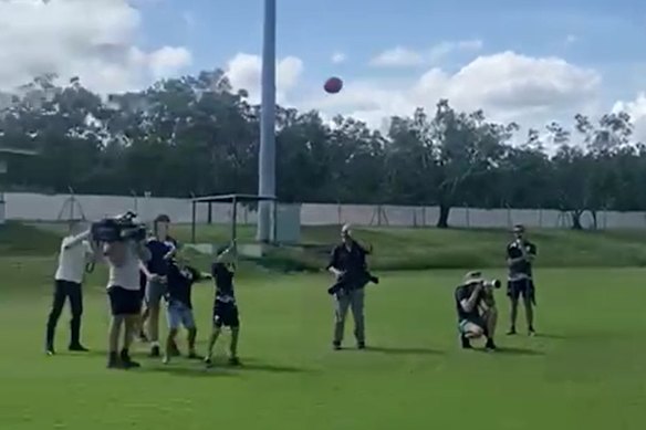 Screengrab showing a TV cameraman being hit by a football kicked by Peter Dutton.