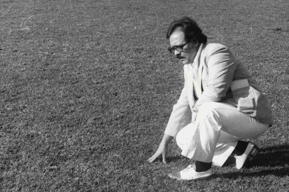 Frank Crook takes a close look at the playing surface at Belmore Sports Ground after the cancellation of a rugby league match between Canterbury and Western Suburbs in June 1980.