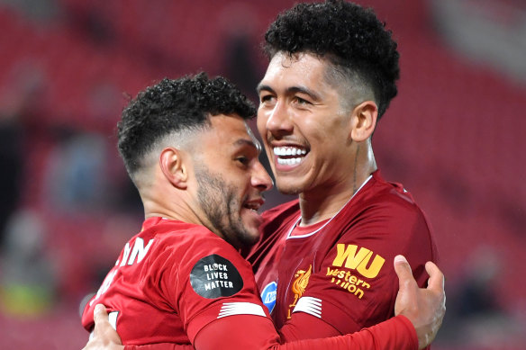 Alex Oxlade-Chamberlain of Liverpool celebrates with teammate Roberto Firmino after scoring his team's fifth goal during the Premier League match between Liverpool FC and Chelsea FC at Anfield.