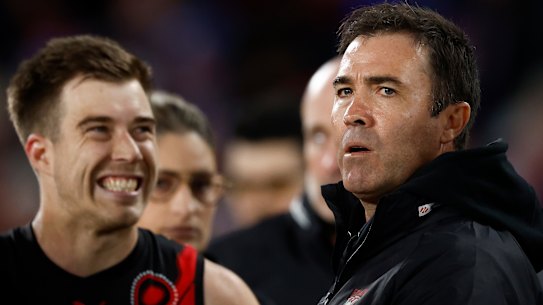 Bombers coach Brad Scott, right, speaks to his players.