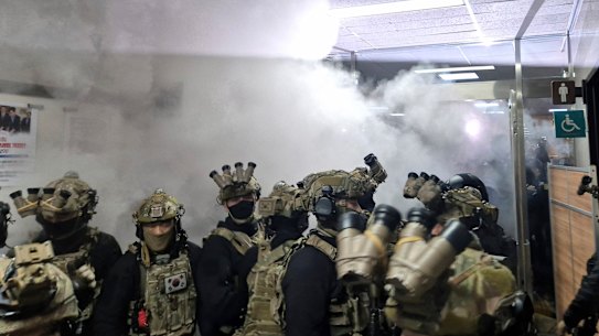 A National Assembly staff sprays fire extinguishers to block soldiers entering the main hall of the National Assembly in Seoul, South Korea.