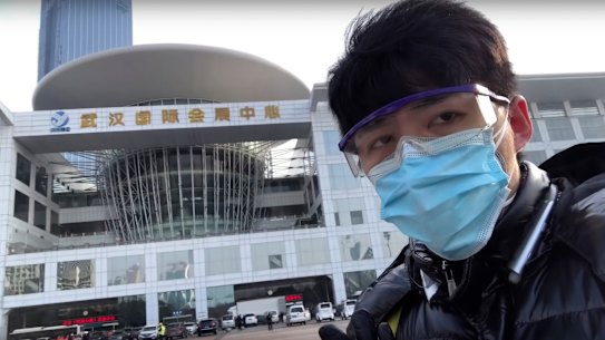 In this image from video taken Feb. 4, 2020 and released by Chen Qiushi, Chinese citizen journalist Chen Qiushi speaks in front of a convention center-turned makeshift hospital amid a viral epidemic in Wuhan in central China's Hubei province.  Armed with smart phones and social media accounts, Chen and other citizen journalists in China are telling stories from the deadly epidemic in their own words, defying the ruling Communist Party's monopoly on information. Chen disappeared last week after garnering millions of views online. (Courtesy of Chen Qiushi via AP)