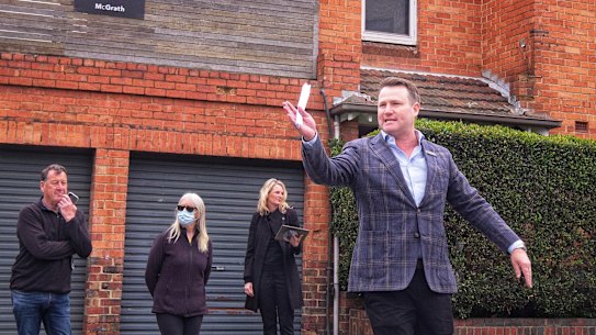 Auctioneer Josh Stirling accepts bids for a property on Brighton Road, St Kilda on Sunday. The 2-bedroom apartment sold for $891,000, which was $100,000 above reserve.