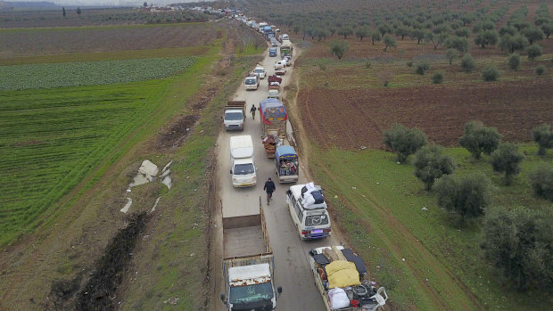Civilians flee from Idlib to find safety inside Syria near the border with Turkey on Tuesday.