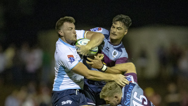 Waratahs back-rower Jack Dempsey is tackled by Reds backs Jordan Petaia and Bryce Hegarty. 