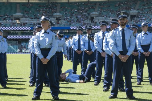 An officer collapses during the  NSW Police Force classes of 2020 Attestation Parade at Sydney Cricket Ground. 4th December 2020.