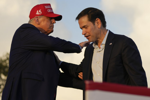 Former president Donald Trump pats Marco Rubio on the shoulder at a campaign rally at the Miami-Dade County Fair in Miami in 2022.