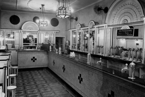 The interior featured a service or fountain bar with its soda fountain pumps and straw dispensers. On the mirrored back bar are the milkshake makers which would whisk the  ingredients.
