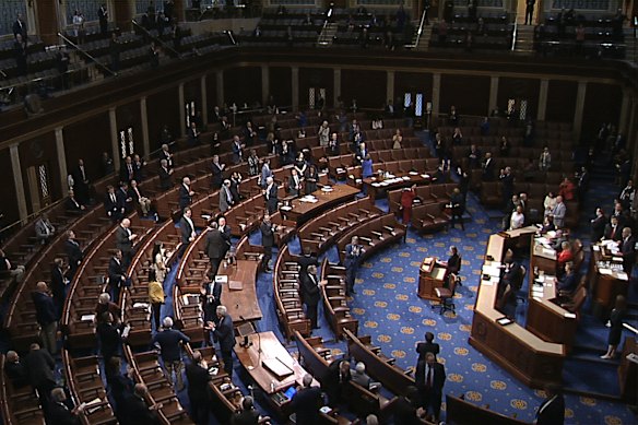 Members of the House stand after they passed the coronavirus stimulus package. 