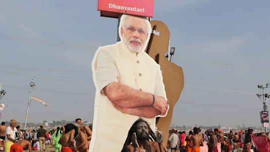 A policeman stands next to a cut out photograph of Indian Prime Minister Narendra Modi as Hindu holy men participate in a ritual after a holy dip at Sangam, the confluence of sacred rivers the Yamuna, the Ganges and the mythical Saraswat in India.