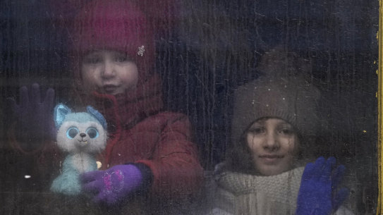 Ukrainian children look out of the window of an unheated Lviv-bound train, in Kyiv, Ukraine.