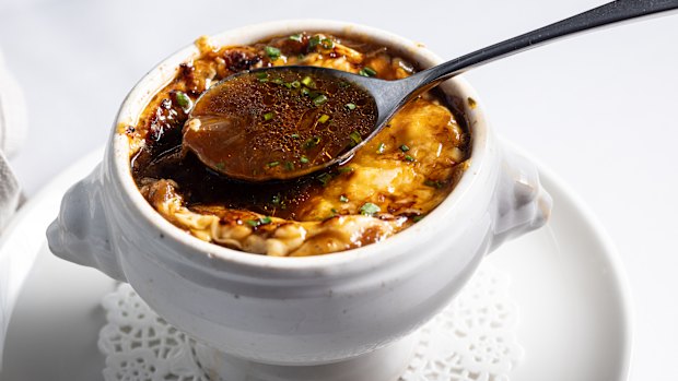 The soup's base is a reduce beef stock of depth and distinction; its cheesy topping grilled to melty magnificence.